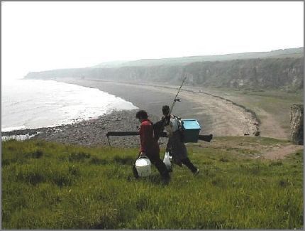 Two fishermen on their way to Noses Point. The Blast Beach stretches below to Choundon Point.  Dawdon Colliery has been closed for ten years and there has been no tipping of waste into sea during most of that period. Now the sea is reclaiming the beach and eroding its way towards the cliffs.