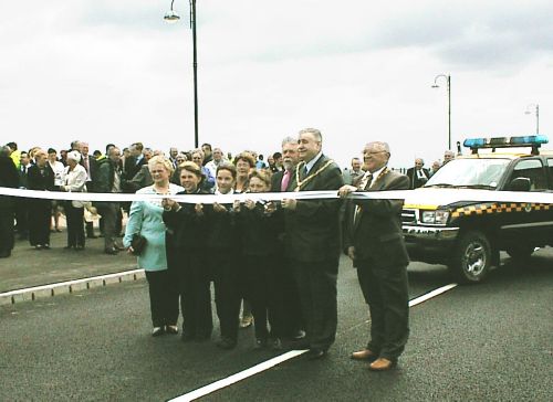 Cllr Alan Fenwick cuts the ribbon to officially open The George Elmy Way. Also pictured are (left to right) Cllr Barbara Ramshaw (Mayor of Seaham); Mrs Dorethea Fenwick (Chairman of Durham C.C Lady) behind children; Phil Hughes (One North East); Cllr Fenwick; Cllr Bill Gustard (Chairman of District of Easington)